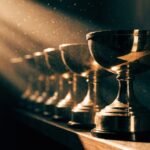 A row of gold trophies in a shaft of warm light