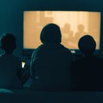 A family watching a glowing screen at home at night