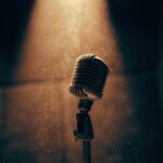 A lone studio microphone in an empty recording booth