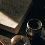 A marked-up screenplay, clapperboard and lens on a dark table